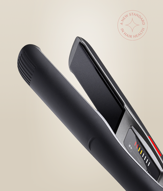 Close-up of the Astral Black Omnia Styler Plus, showing its open plates and colour-coded temperature controls.